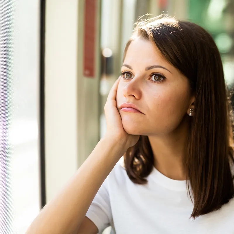 An unhappy woman staring out a window