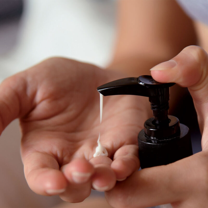 A woman pumping CBD lotion into her hand.