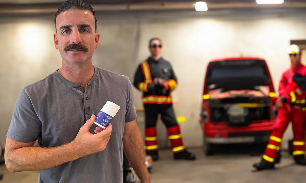 A firefighter holding a bottle of CBD cream.