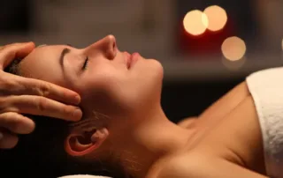 A woman getting her temples massaged.