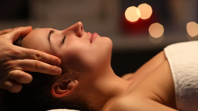 A woman getting her temples massaged.