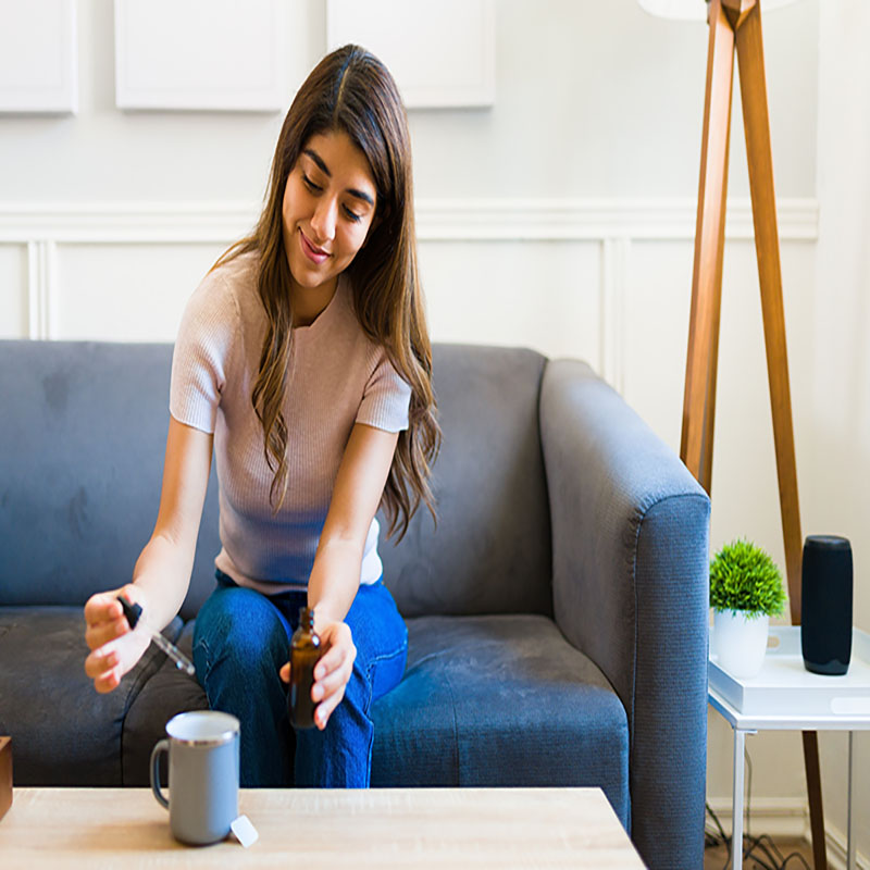 Woman putting cbd oil in tea