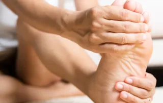 A woman rubbing her foot with diabetic pain.