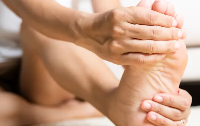 A woman rubbing her foot with diabetic pain.